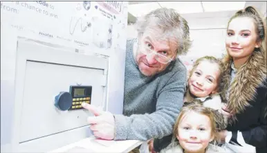  ?? Picture: Martin Apps FM4673658 ?? Andy Dwyer with daughters Esme, Bibby and Lily from Bredgar try to crack the safe at Fremlin Walk to win £20,000 worth of jewellery for Valentine’s Day