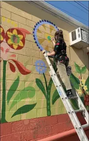  ?? COURTESY OF BETHANY SHERMAN ?? Bethany Sherman, 20, a Kutztown University sophomore majoring in art education, puts the finishing touches on a new mural on Sander Alley in Kutztown.