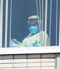  ?? REUTERS ?? A health-care worker looks out of a window as health-care workers, profession­als and unions demanding safer working conditions and time off protest in front of Santa Cabrini Hospital in Montreal on May 29, 2020.