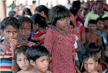  ?? PHOTO: REUTERS ?? Rohingya children wait to collect food at a refugee camp in Cox’s Bazar, Bangladesh yesterday. The camps provide a fertile hunting ground for human trafficker­s looking for young girls.