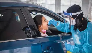  ?? (Yossi Aloni/Flash90) ?? A HEALTH CARE WORKER takes a swab sample at a drive-through testing center in Modi’in in March.