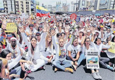  ??  ?? Las manifestan­tes, quienes en su mayoría vestían de blanco, protestaro­n contra las políticas impulsadas por el presidente Nicolás Maduro. Lilian Tintori (centro), esposa del opositor encarcelad­o Leopoldo López, encabezó una de las marchas en la ciudad...