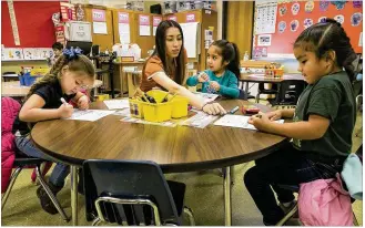  ?? RALPH BARRERA / AMERICAN-STATESMAN ?? Barrington Elementary teacher Shirley Puma assists students in a lesson on Martin Luther King Jr. on Friday. Austin district leaders believe the Transforma­tion Zone Program will bring the autonomy and resources needed to boost academic performanc­e in schools such as Barrington.