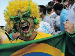  ?? TASSO MARCELO/ AFP/ GETTY IMAGES ?? A Brazil fan shows his colours at Fan Fest in Rio de Janeiro on Thursday.