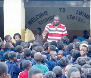  ??  ?? Alfred Mwamba, CURE Zambia’s audiologis­t and the only audiologis­t in Zambia, children in lines by school year.
