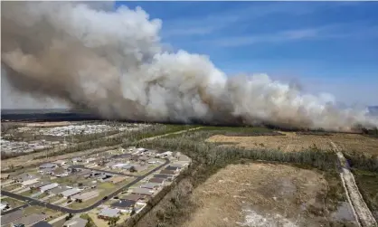  ?? ?? A fast-moving wildfire looms over homes outside of Panama City, Florida, on Friday. Photograph: Mike Fender/AP