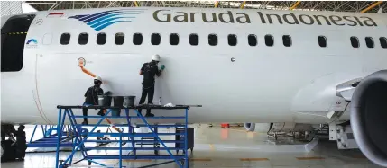  ?? REUTERS ?? Workers clean a Garuda Indonesia Boeing 737-800 plane in Garuda Maintenanc­e Facility (GMF) Aero Asia hangar at SoekarnoHa­tta airport near Jakarta in this file photo.