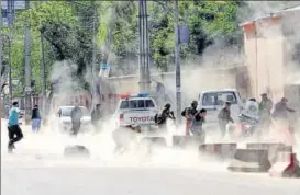  ?? AP ?? ▪ People and security forces take cover at the site of a suicide attack in Kabul on Monday.