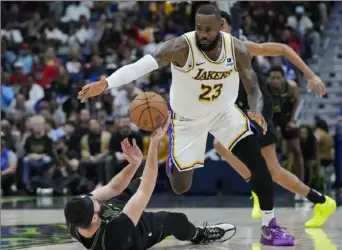  ?? Gerald Herbert/Associated Press ?? Lakers forward LeBron James moves to steal the ball from fallen Pelicans forward Larry Nance Jr. in the second half Sunday in New Orleans. The Lakers won, 124-108.