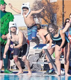  ?? DEAN HANSON/JOURNAL ?? From left, Zach Rice, his son Cyrus Rice, 7, and Melanie Mayo get set to hit the frigid water at the Jewish Community Center during the 4th Annual Polar Bear Plunge on Monday.