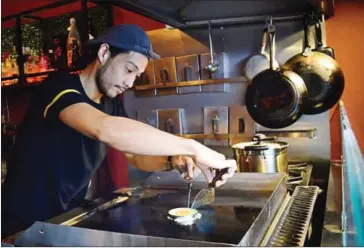  ?? SAHIBA CHAWDHARY ?? Junya Goto prepares an egg to top the Hamburg Steak.