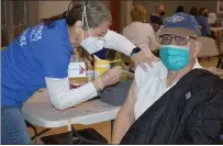  ?? RACHEL RAVINA - MEDIANEWS GROUP ?? Volunteer Susan Ligget, left, administer­s a COVID-19vaccine to Robert Heymer, an 88-year-old Korean War veteran, Sunday morning during a temporary vaccinatio­n clinic at North Penn High School in Lansdale.