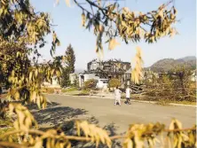  ?? Noah Berger / Special to The Chronicle ?? Following the Glass Fire, Skyhawkare­a residents walk past burned homes on Mountain Hawk Drive in Santa Rosa.