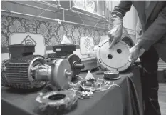  ?? ASSOCIATED PRESS ?? An Iranian nuclear technician shows a part of a machine of the country’s nuclear facilities in a display of various parts and equipment from valves and pumps to electro motors, modems and barometers that they say were exported to the country with the...