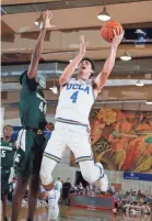  ?? BRIAN SPURLOCK/USA TODAY SPORTS ?? UCLA guard Jaime Jaquez Jr. takes a shot in the loss to Michigan State and Gabe Brown in 2019.