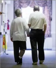  ?? MATT ROURKE — THE ASSOCIATED PRESS FILE ?? In this file photo, an elderly couple walks down a hall in Easton, Pa. It’s not too late to get moving: Simple physical activity, mostly walking, helped high-risk seniors stay mobile after disability-inducing ailments even if, at 70 and beyond, they’d...