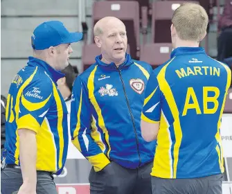  ?? ANDREW VAUGHAN, THE CANADIAN PRESS ?? Canadian curling great Kevin Martin, coach of the Alberta team, talks with Darren Moulding, left, and his son Karrick Martin during action at the Tim Hortons Brier in St. John’s.