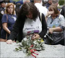  ?? SETH WENIG — THE ASSOCIATED PRESS ?? Tina Tilearcio pauses at a stone that is part of the new 9/11 Memorial Glade on the grounds of the National September 11 Memorial & Museum, after its dedication ceremony in New York. Her husband, Robert Tilearcio, died in 2017 of illness related to his recovery work at ground zero.