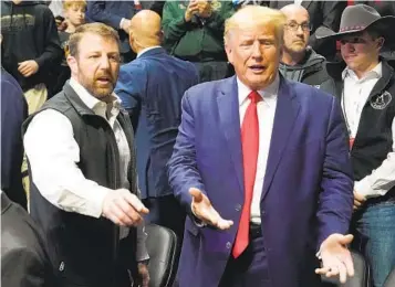  ?? SUE OGROCKI AP ?? Sen. Markwayne Mullin, R-Okla., and former President Donald Trump gesture to fans as they talk before the NCAA Division I Wrestling Championsh­ips on Saturday in Tulsa, Okla.