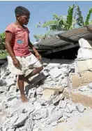  ?? —GRIG C. MONTEGRAND­E ?? QUAKE DAMAGE An Aeta resident in Floridabla­nca, Pampanga, checks his house after it crumbled when a 6.1magnitude earthquake struck in April.