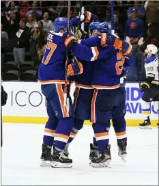  ?? KATHLEEN MALONE-VAN DYKE — THE ASSOCIATED PRESS ?? Islanders players celebrate an overtime goal during a game against the Blues Monday in Uniondale, N.Y.