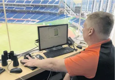  ?? WELLS DUSENBURY/SUN SENTINEL ?? Mike McKeon operates the team’s retractabl­e roof at Marlins Park from the stadium’s command center. McKeon must keep his finger on the biometric sensor for the entirety of the 13-minute process for the roof to close.
