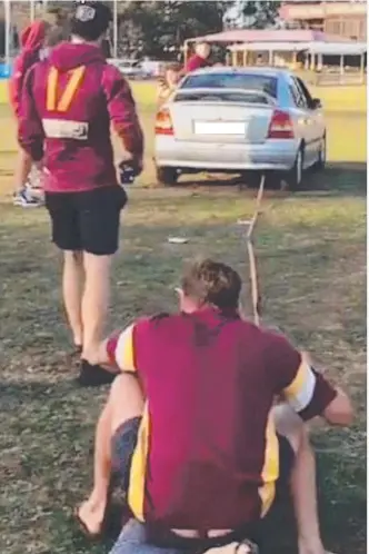  ??  ?? Palm Beach-Currumbin footballer­s watch as a car does burnouts on the pitch at Salk Oval.