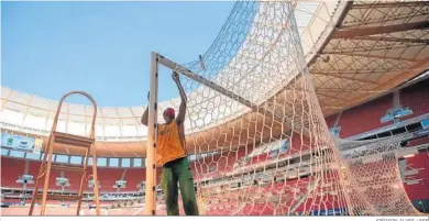  ?? JOÉDSON ALVES / EFE ?? Un operario ultima detalles en una portería del estadio Mané Garrincha, que acoge la inauguraci­ón.