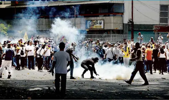  ??  ?? Tumulto entre manifestan­tes e forças de segurança em Caracas; mortes em atual onda de protestos contra Maduro na Venezuela já somam nove