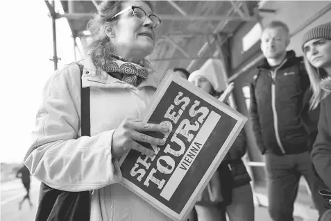  ??  ?? A homeless tour guide Barbara talks to tourists near Hauptbahnh­of main train station during her ‘Shades Tours’ trip around the Austrian capital in Vienna on Oct 30, 2016.