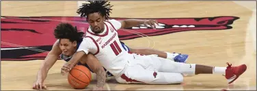  ?? (NWA Democrat-Gazette/J.T. Wampler) ?? Jalen Tate, shown fighting for a loose ball with Texas-Arlington’s Fredelin De La Cruz earlier this month, is averaging 10.5 points, 4.7 assists and 4.9 rebounds per game this season going into Arkansas’ game against Oral Roberts on Sunday.