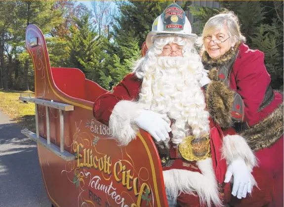  ?? KARL MERTON FERRON/BALTIMORE SUN PHOTOS ?? Santa Claus and Mrs. Claus (played by Craig Ralston and Kathleen “Kat” Ralston) with the custom-built sleigh at Howard County Volunteer Fire Department Station 8.