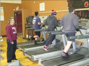  ??  ?? Nancy Giordano watches two Villa Novan runners and a wrestling team member working out on the treadmills.