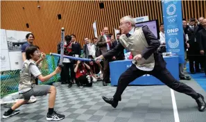  ?? AP Photo/Koji Sasahara, Pool ?? ■ IOC President Thomas Bach, right, performs mock fencing with Japanese junior high school student Yui Hashimoto during an Olympic Games Tokyo 2020 event Wednesday in Tokyo. Bach is a former Olympic fencer and won a team gold medal at the 1976 Montreal Games. Fans, sponsors and politician­s celebrated the day around the Japanese capital, displaying placards and clocks showing 365 days to go until the opening ceremony on July 24, 2020.