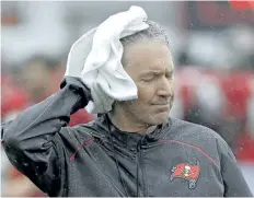  ?? CHRIS O’MEARA/THE ASSOCIATED PRESS ?? Tampa Bay Buccaneers head coach Dirk Koetter towels off as rains from tropical storm Emily fall during an NFL football training camp practice.