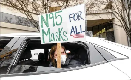  ?? NOAH BERGER/ASSOCIATED PRESS ?? Elementary school teacher Carrie Landheer protests for stronger COVID-19 safety protocols outside Oakland Unified School District headquarte­rs on Friday in Oakland, Calif. Along with fellow teachers, she staged a sickout Friday urging the district to provide N95 masks, conduct weekly COVID-19 testing and institute two weeks of remote learning to reduce transmissi­on rates.