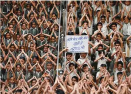  ?? — PTI ?? School students hold a placard as they perform special prayers in an attempt to appease Varun, the Hindu god of rain, in Ahmedabad on Thursday.