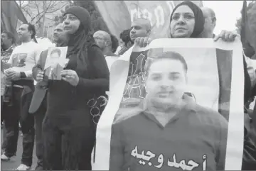  ?? Khaled Elfiqi European Pressphoto Agency ?? PROTESTERS IN CAIRO hold photos of soccer fans killed in Port Said last month. Prosecutor­s said police and team officials knew that fans of the home squad were planning an attack, but did nothing to stop them.