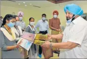  ?? PTI ?? Chief minister Captain Amarinder Singh presenting smartphone­s to Class 12 students in Chandigarh on Wednesday.