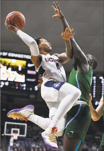  ?? Jessica Hill / Associated Press ?? UConn’s Jalen Adams (4) goes up to the basket as Tulane’s Jordan Cornish defends on Saturday.