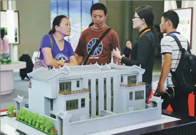  ?? WU CHANGQING / FOR CHINA DAILY ?? A saleswoman introduces a housing project at a property fair in Beijing on Sept 13.