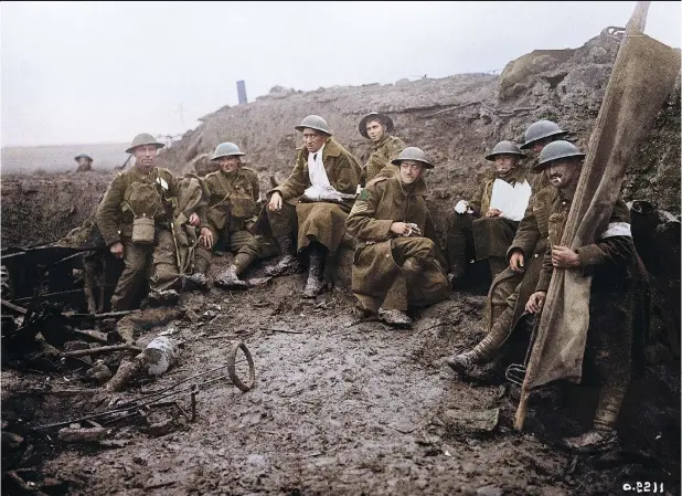  ??  ?? Wounded Canadians take cover, above, behind a bunker at the Battle of Passchenda­ele. Below: Canadian Pioneers carry trench mats, with wounded soldiers and prisoners in background. PHOTOS FROM CANADA. DEPT. OF NATIONAL DEFENCE / LIBRARY AND ARCHIVES...