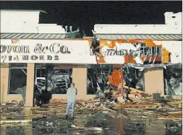  ?? Dave Scherbenco ?? The Associated Press A bystander stands in front of several businesses in the area of the Wilkes Barre Township Commons after high winds ripped through the area, damaging several buildings and injuring multiple people Thursday in Wilkes Barre Township,...