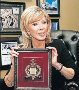  ?? [SUE OGROCKI/THE ASSOCIATED PRESS] ?? Carol Mersch holds a copy of a microfilm Bible that flew around the moon on Apollo 13. Behind her in her Tulsa, Okla., home are some of the photograph­s and space program memorabili­a she has collected. Ten microfilm Bibles launched hundreds of thousands...