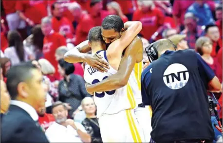  ?? AFP ?? The Golden State Warriors’ Stephen Curry and Kevin Durant (right) hug in Game 7 of the Western Conference finals against the Houston Rockets in the 2018 NBA Playoffs on Monday at the Toyota Center in Houston, Texas.