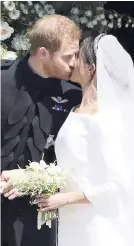  ??  ?? Britain’s Prince Harry and Meghan Markle steal a kiss, while leaving their wedding ceremony at St George’s Chapel in Windsor Castle recently.