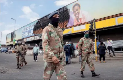  ??  ?? Soldados das Forças de Defesa da África do Sul patrulham as ruas