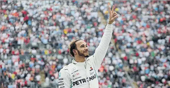  ?? FOTO: AP ?? Lewis Hamilton hace el signo de la victoria tras bajarse de su Mercedes en la zona del Foro Sol después de la carrera de México, ya como nuevo campeón del mundo de Fórmula 1