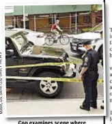  ??  ?? Cop examines scene where woman was hit and killed Thursday on Upper West Side.