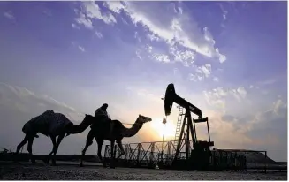  ?? HASAN JAMALI / ASSOCIATED PRESS 2015 ?? A man rides a camel through a desert oil field and winter camping area in Sakhir, Bahrain. OPEC ministers reached a preliminar­y deal late Wednesday in Algeria to cut production for the first time since the global financial crisis eight years ago. The...